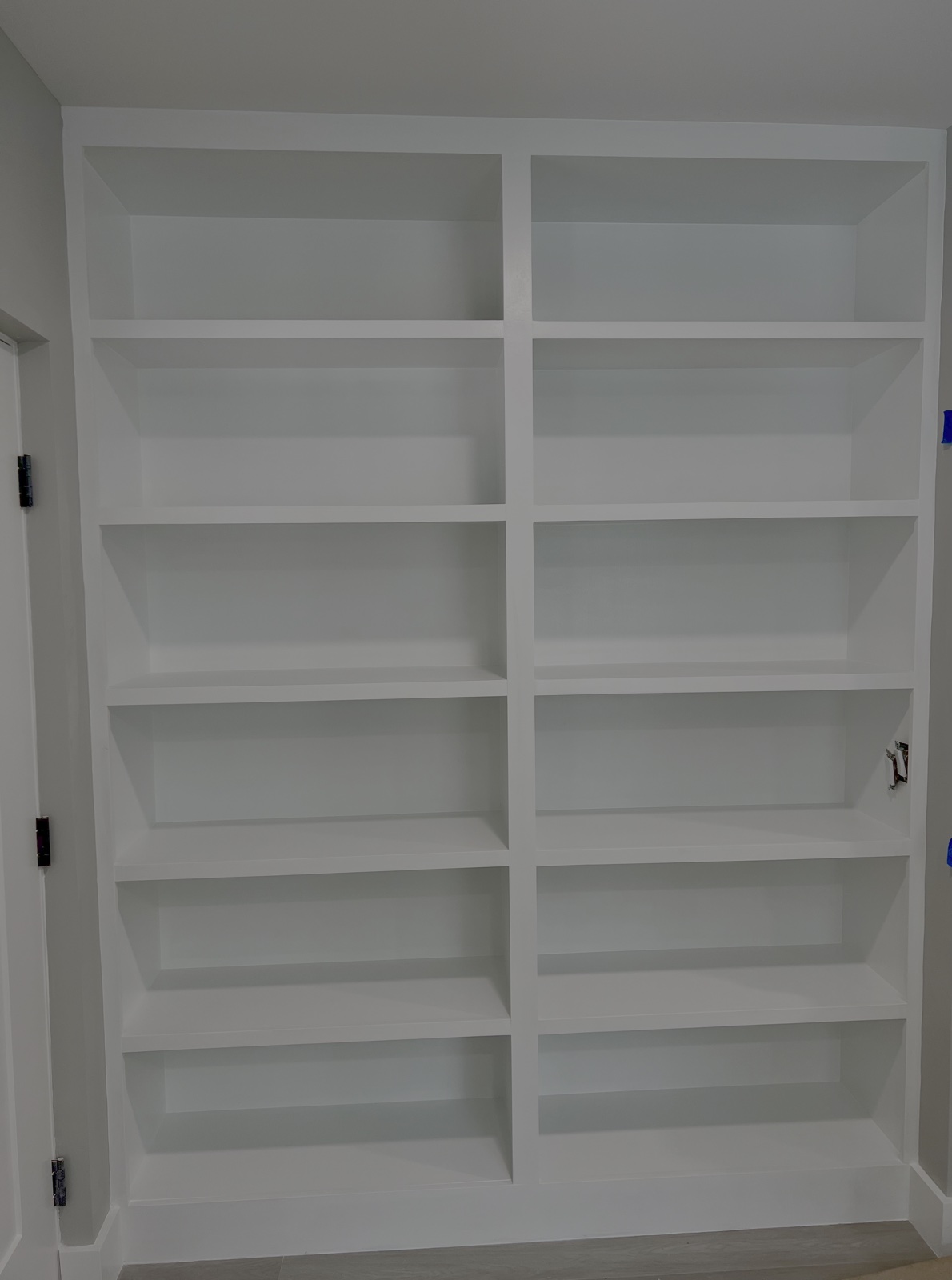 Custom floor-to-ceiling white built-in bookcase cabinetry handcrafted in Bradenton FL by Suncoast Precision Carpentry