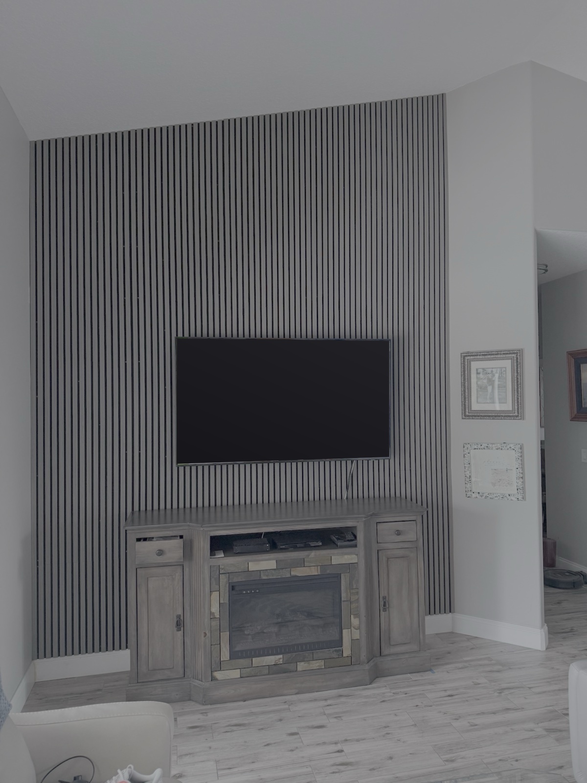 Floor-to-ceiling modern acoustic charcoal wood slat feature wall and TV unit by Suncoast Precision Carpentry